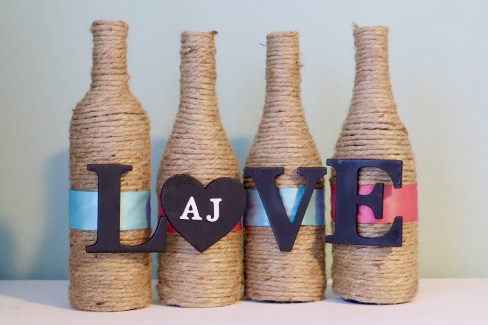 gift for the wine lover: set of 4 wine bottle vases on shelf with "love"