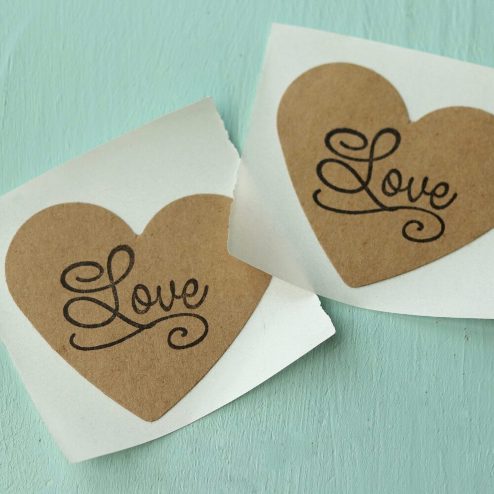 heart shaped envelope stickers on teal background with "love" stamp
